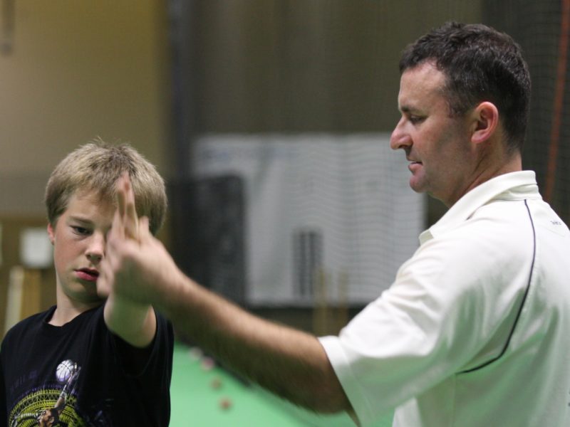 Luke Winbridge coaching a young cricket player